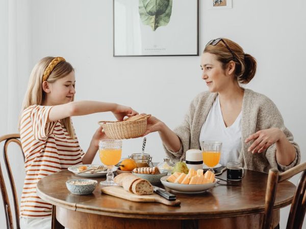 A warm family breakfast with mother and daughter sharing a meal in a cozy dining area.